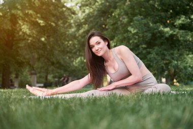 İnce vücutlu ve uzun saçlı güzel bir kız sıcak bir yaz gününde spor için parka gider. Sağlıklı yaşam tarzı kavramı.