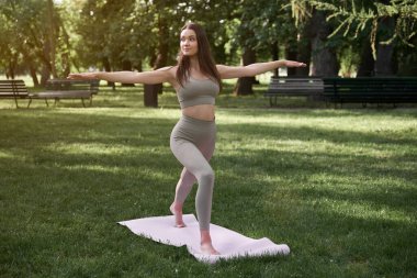 İnce vücutlu ve uzun saçlı güzel bir kadın sıcak bir yaz gününde spor için parka gider. Sağlıklı yaşam tarzı kavramı.