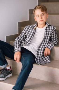 Yakışıklı, gülümseyen genç bir adam. Kapalı alanlarda oturuyor. Yeni nesil