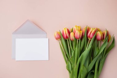 Tebrik kartı modeli ya da teşekkür kartı şablonu bej arka planda bir buket lale ile.