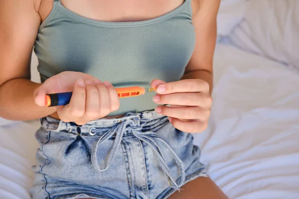 A child uses an insulin pen to inject insulin at home. Lifestyle of a child with diabetes.