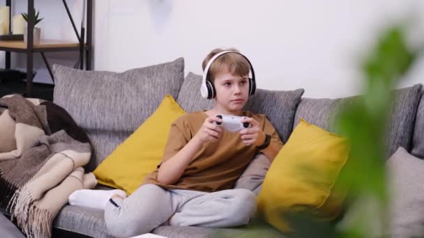 Мальчик Подросток Играющий Видеоигры Джойстиком Сидит Дома Диване — стоковое видео