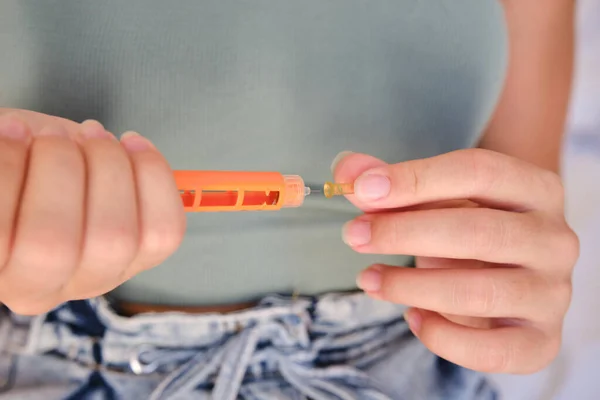 Close-up of a girl using an insulin pen to inject insulin at home. Lifestyle of a child with diabetes.