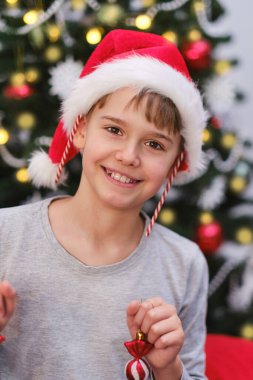 Kulaklarında ve ellerinde Noel süsleri olan sevimli, komik bir bebek. Noel mutluluğu
