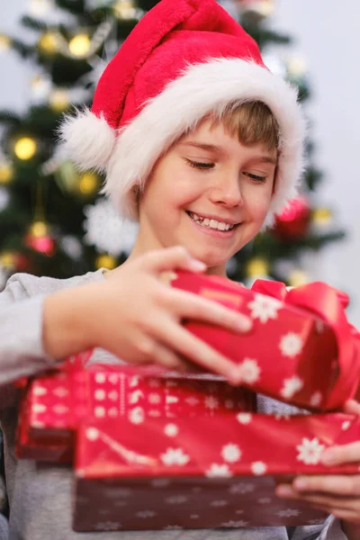 Niño Feliz Sombrero Santa Sosteniendo Pila Regalos Navidad Felices Vacaciones — Foto de Stock