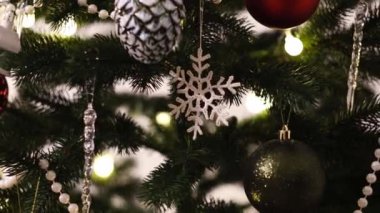 Close-Up Of Christmas Decorations On Green Christmas Tree. Knitted snowflake on a spruce branch