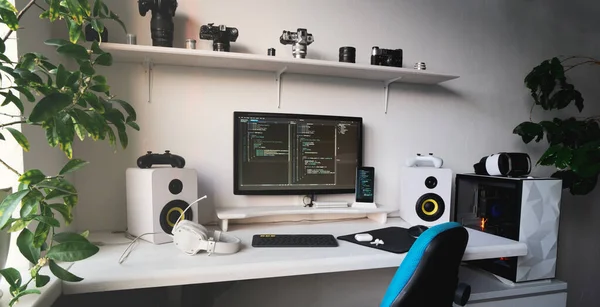 Bilgisayar masaüstü ve rahat koltuğu olan kod yazmak için boş modern geliştirici çalışma yeri Stok Resim