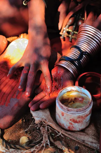 Himba woman mixing red ochre with petroleum jelly — Stock Photo, Image