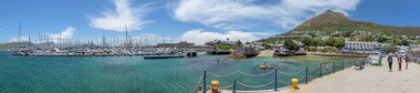 SIMONSTOWN,  SOUTH AFRICA - DEC 23, 2021: Panorama of the harbour and waterfront in Simonstown, Western Cape Province of South Africa. Buildings, boats and people are visible