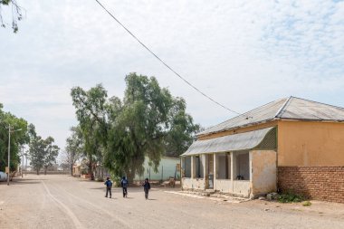 VICTORIA BATI, GÜNEY AFRİKA - SEP 2, 2022: Victoria West, Kuzey Karoo Burnu 'ndaki tarihi evler ve ağaçlarla dolu bir sokak sahnesi. Çocuklar okuldan eve dönerken görülüyor.