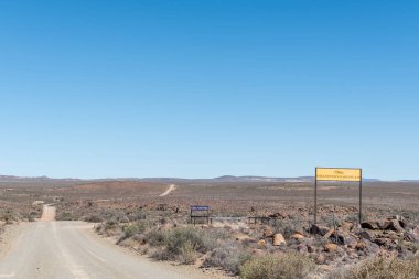 FRASERBURG, SOUTH AFRICA - SEP 3, 2022: Fraserburg ve Sutherland arasındaki tarihi Posta Yolu üzerindeki Eselfontein Misafir Çiftliğinde isim tahtalarına sahip yol manzarası