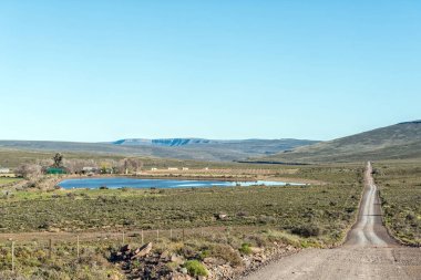 Kuzey Cape Eyaleti 'ndeki Sutherland yakınlarındaki Bo-Visrivier yolunda yol manzarası. Çiftlik Kanolfontein görünür.
