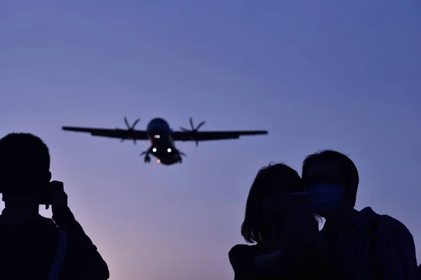 Tres Personas Mirando Avión Volador Contra Cielo Azul Durante Atardecer —  Fotos de Stock