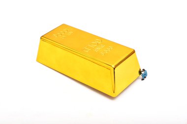 Minyatür insanlar, beyaz arka planda altın çubuğu olan küçük model işçi figürü.