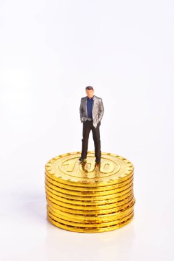 Altın sikkeler, iş adamları ve finansal kavramlar üzerinde duran minyatür insanlar.    