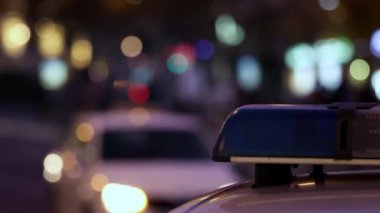 Gece şehir caddesinde polis arabasının sireninin mavi ışığı. Temalar suç, acil durum ve yardım. 