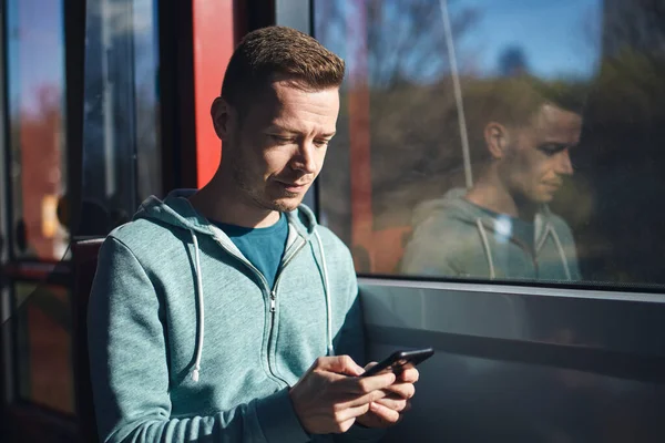 Man Using Phone While Commuting Tram Public Transportation — ストック写真