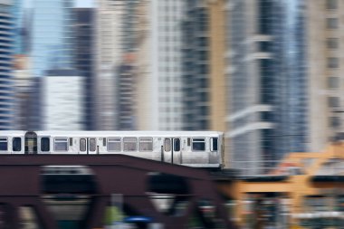 Chicago 'daki yükseltilmiş tren şehir merkezindeki gökdelenlere karşı tren köprüsünden geçiyor..
