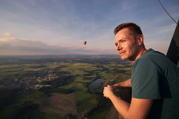 日没の美しい風景の上の飛行中に熱気球からの眺めを楽しむ男 テーマ冒険 自由と旅行 — ストック写真
