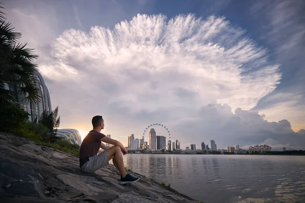 Νεαρός Που Κάθεται Στην Προκυμαία Και Κοιτάζει Δραματικά Σύννεφα Καταιγίδας — Φωτογραφία Αρχείου