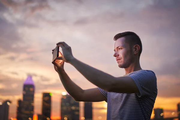 新加坡 在金色日落时 人们通过城市天际线的手机拍照 — 图库照片