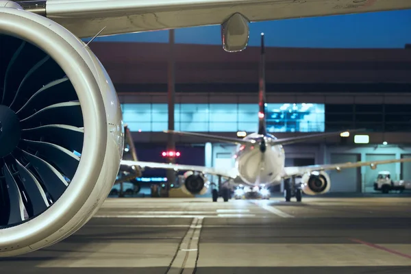 Close-up of jet engine of plane at busy airport. Preparation of airpane before night flight