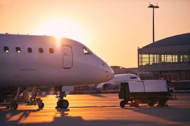 Preparation of airplanes before flight. Airport at golden sunrise.