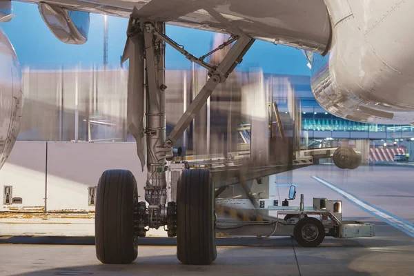 Loading of airplane at airport. Cargo container in blurred motion