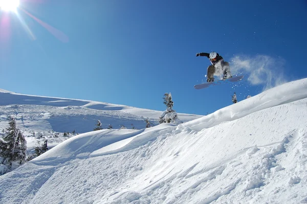 Snowboarder σε δράση σε μια ηλιόλουστη μέρα του χειμώνα. — Φωτογραφία Αρχείου