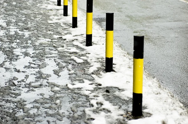 Деталь дороги и пешеходной зоны со снегом в зимнее время — стоковое фото