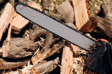 Elektrikli testere yakın çekim. Bir aletle testere. Yakacak odunun arka planında elektrikli testere