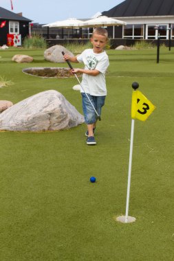 Yaz aylarında minigolf oynayan çocuk