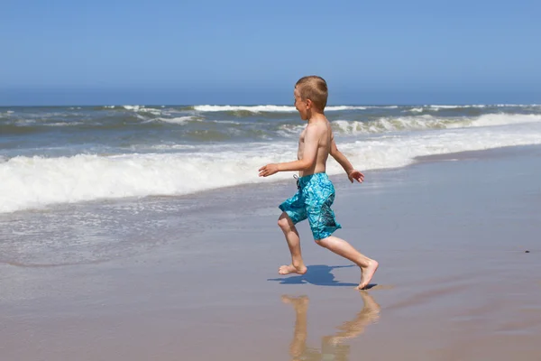 Chlapec běh do oceánu — Stock fotografie