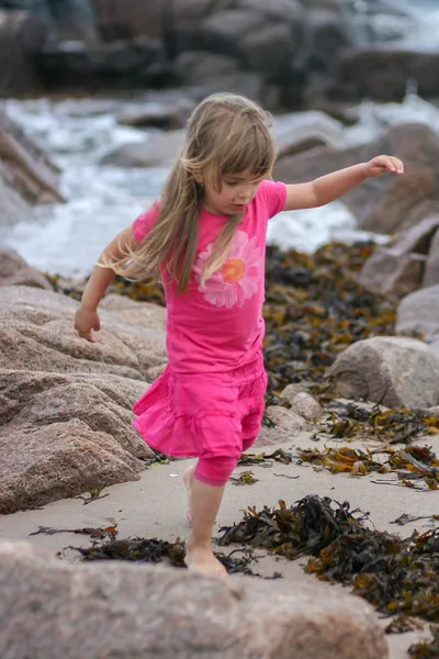 Jonge meisje op rotsachtige strand — Stockfoto