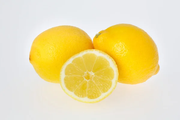 Нарізаним лимоном перед двома лимони — стокове фото