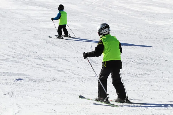 Two Young Skiers Wearing Green Vests — Stock Photo, Image