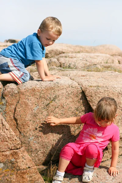 Kleinkinder klettern einen Felsen hinunter — Stockfoto