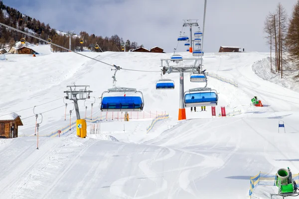 日当たりの良いスキー場の斜面の上の青いチェアリフト — ストック写真