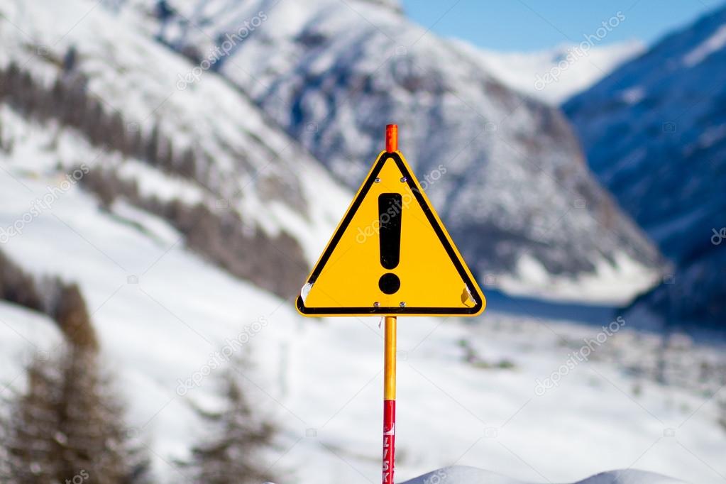 Yellow Danger Sign on Snowy Mountain