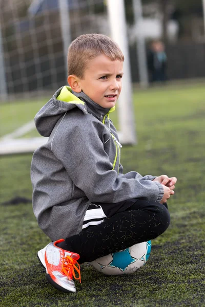 Αγόρι καθιστός σε μπάλα ποδοσφαίρου — Φωτογραφία Αρχείου