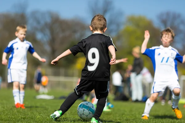 Junge dribbelt während Fußballspiel — Stockfoto