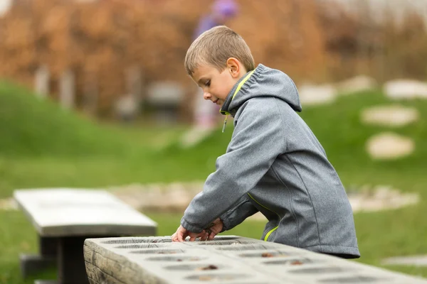 Jongen mancala met zichzelf spelen — Stockfoto