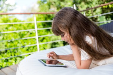 verandada tablet ile oynayan kız