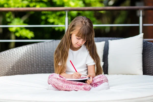 Ragazza seduta sul patio con blocco note — Foto Stock