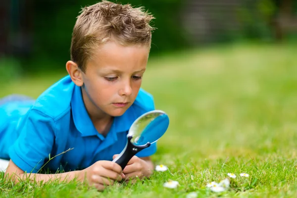 Junge mit Lupe im Garten — Stockfoto