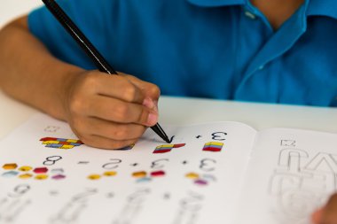 Çocuk ödevini yapıyor.