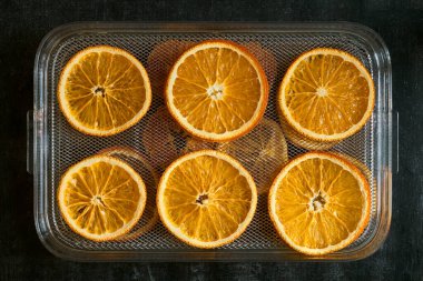 Kurutucu ağ tepsisi portakal dilimleri, üst görünüm, yakın çekim, kurutucu meyve, sağlıklı beslenme.