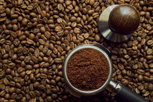 Houder Met Vers Gemalen Koffie Ligt Een Achtergrond Van Vers — Stockfoto