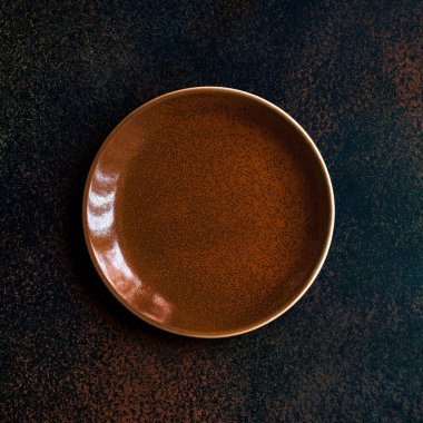 Koyu arkaplanda boş zencefil rengi tabağı. Üst görünüm, kopyalama alanı ile