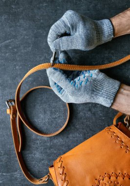 Deri ustası deri bir çanta tamir eder, üst tarafı görür ve kapatır.